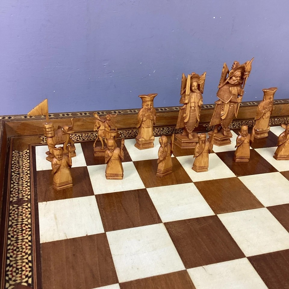 Hand Made Wooden Chess Board + Oriental Carved Chess Set Pieces. Intricate chess pieces displayed on a handcrafted chess board.