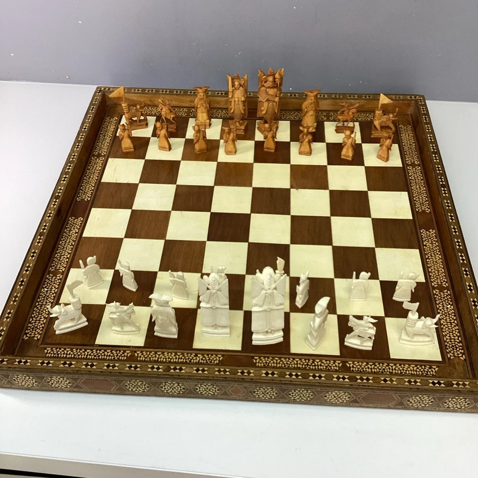 Hand Made Wooden Chess Board + Oriental Carved Chess Set Pieces displayed on a stylish table with detailed craftsmanship.